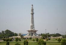 White Concrete Tower Surrounded by Green Grass Field