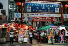 A street with people walking and a sign that says tian petaling street