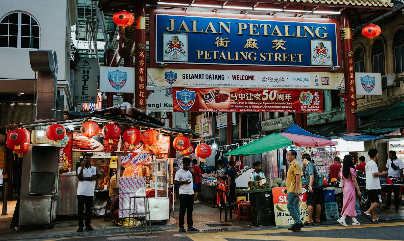 A street with people walking and a sign that says tian petaling street