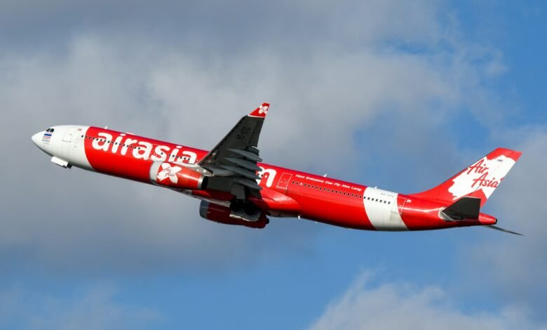 A large air plane flying through a cloudy sky