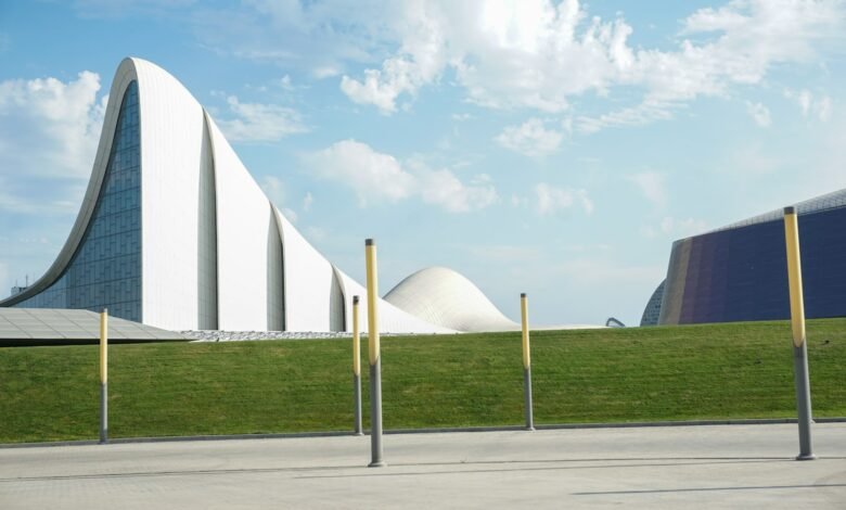 a large white building sitting on top of a lush green field