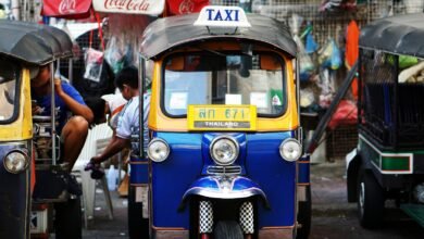 yellow and blue auto rickshaw parked beside auto rickshaw