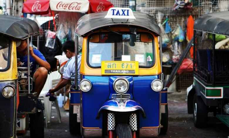 yellow and blue auto rickshaw parked beside auto rickshaw