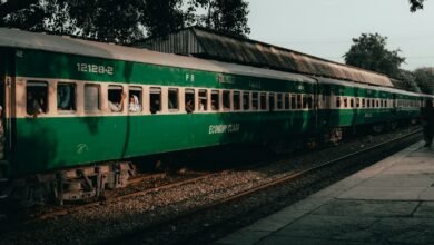 a green passenger train sitting on top of train tracks