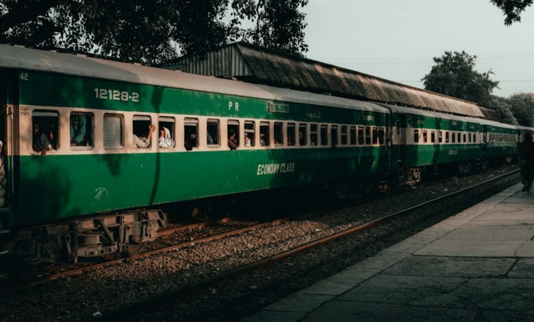 a green passenger train sitting on top of train tracks