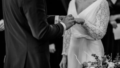 grayscale photo of man insert ring into woman during wedding ceremony