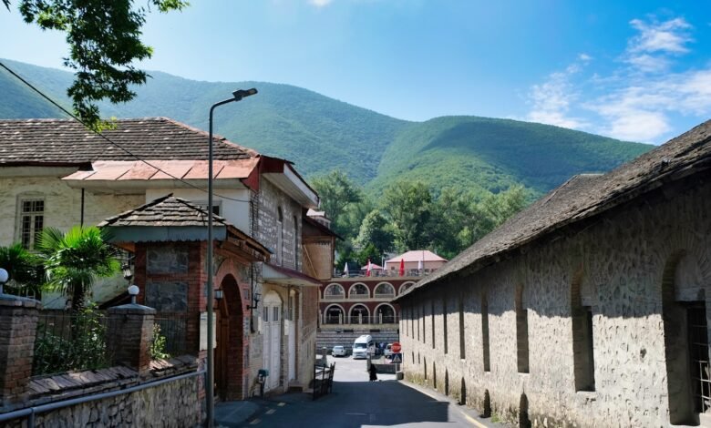 a street lined with stone buildings with mountains in the background