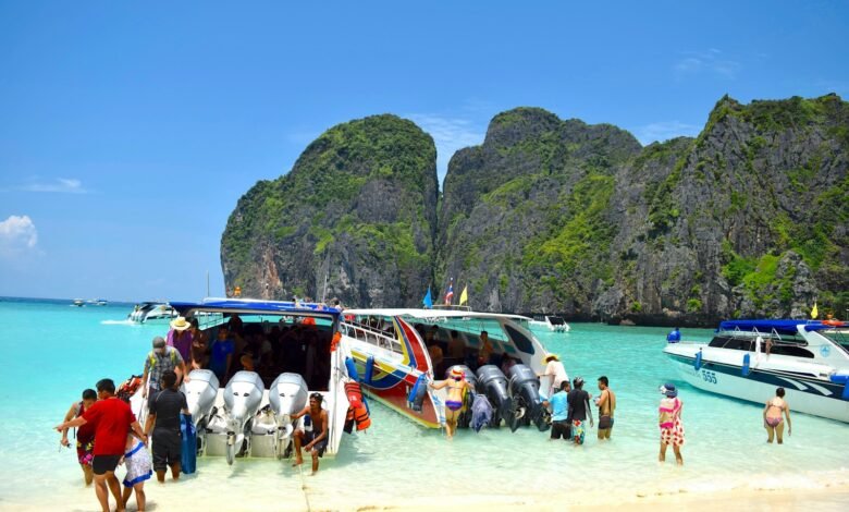 a group of people standing on a beach next to a boat