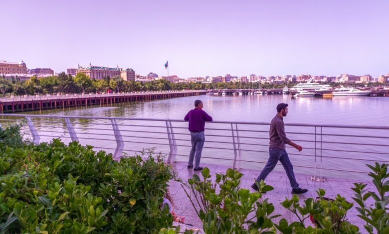 a couple of men walking across a bridge over a river