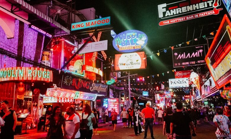 people standing between store buildings at nighttime