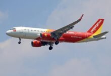 A VietJet Air Airbus A320 captured mid-flight against a clear sky, showcasing vibrant branding.