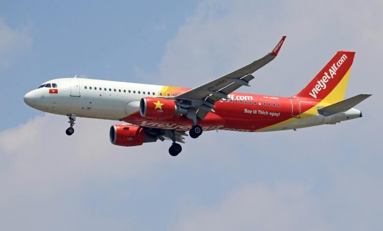 A VietJet Air Airbus A320 captured mid-flight against a clear sky, showcasing vibrant branding.