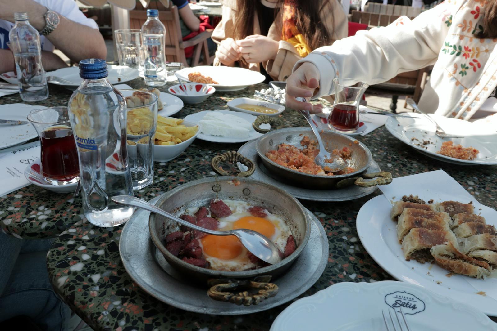 A vibrant Turkish breakfast scene with diverse dishes and tea in a cozy İstanbul café.