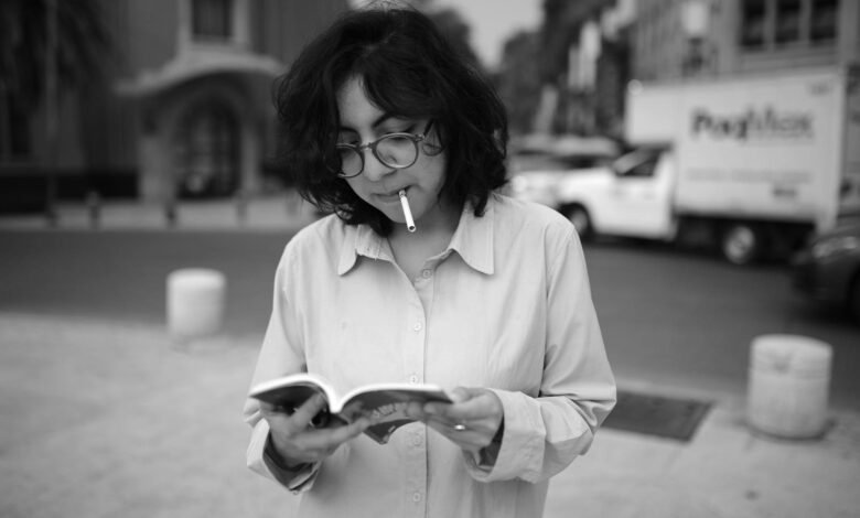 Casual black and white portrait of a woman reading in Mexico City's street.