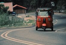 red car on gray asphalt road during daytime