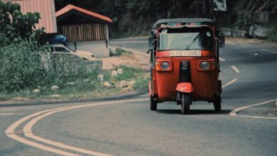 red car on gray asphalt road during daytime