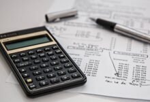 Close-up of financial documents with calculator and pen, ideal for business management themes.