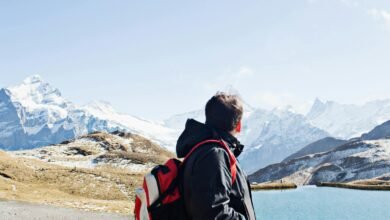 A hiker with a backpack exploring the stunning snowy landscapes of the Swiss Alps near Grindelwald.