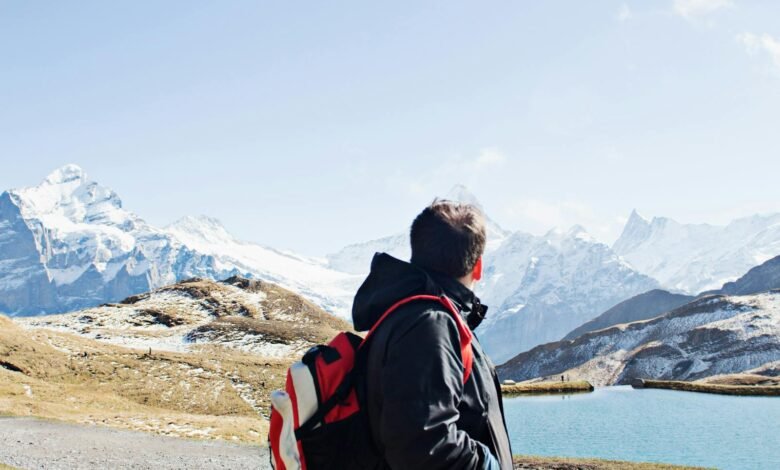 A hiker with a backpack exploring the stunning snowy landscapes of the Swiss Alps near Grindelwald.