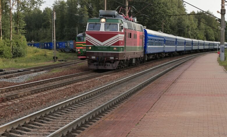 a train traveling down train tracks next to a forest