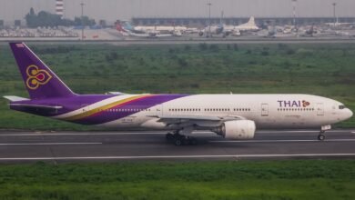 A thai airlines plane on the runway at an airport