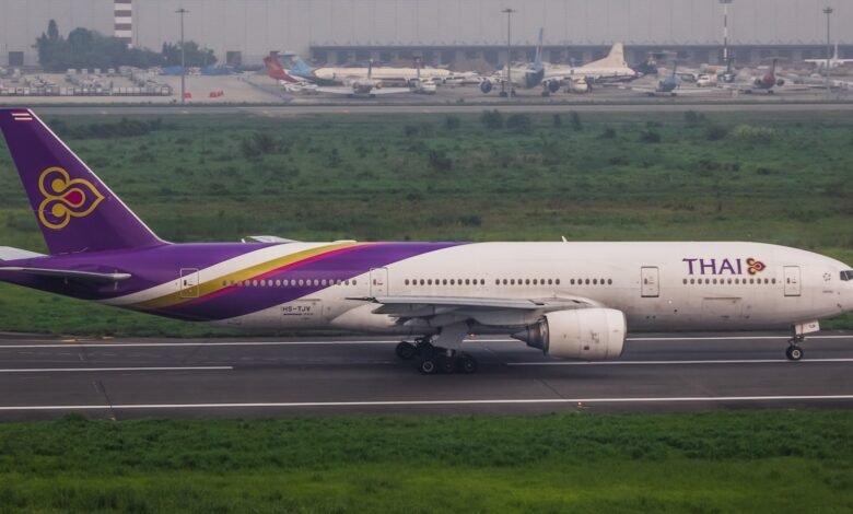 A thai airlines plane on the runway at an airport