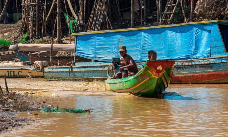 man in black shirt riding on green and yellow boat during daytime