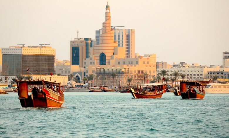 a group of boats in a body of water with buildings in the background