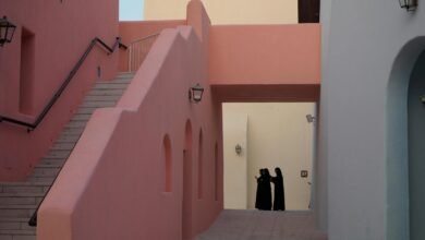 Colorful buildings and people in traditional attire in Katara Cultural Village, Doha.