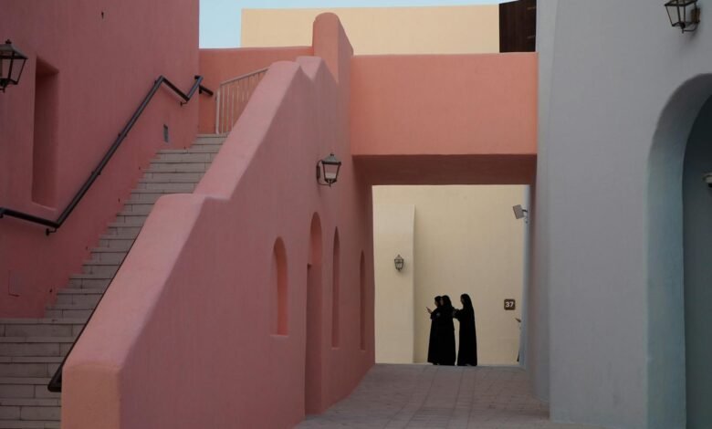 Colorful buildings and people in traditional attire in Katara Cultural Village, Doha.
