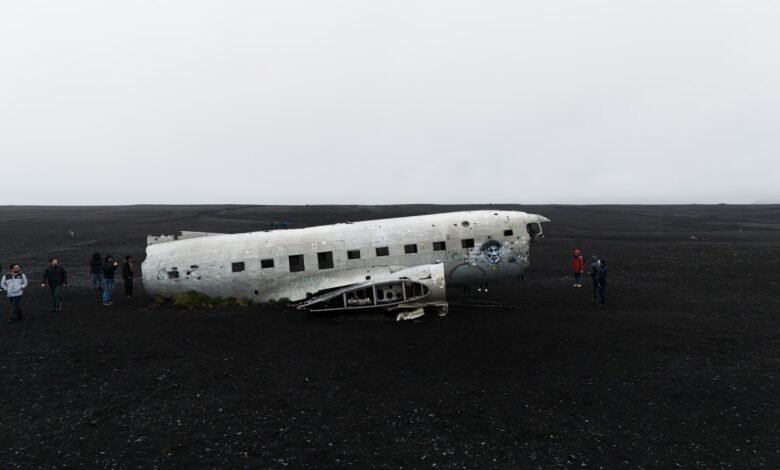 a group of people standing around an old airplane