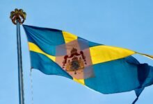 a flag flying in the wind with a blue sky in the background