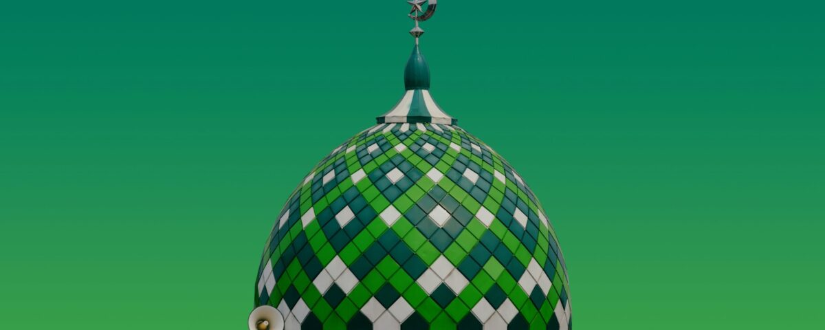 A green and white building with a clock on top