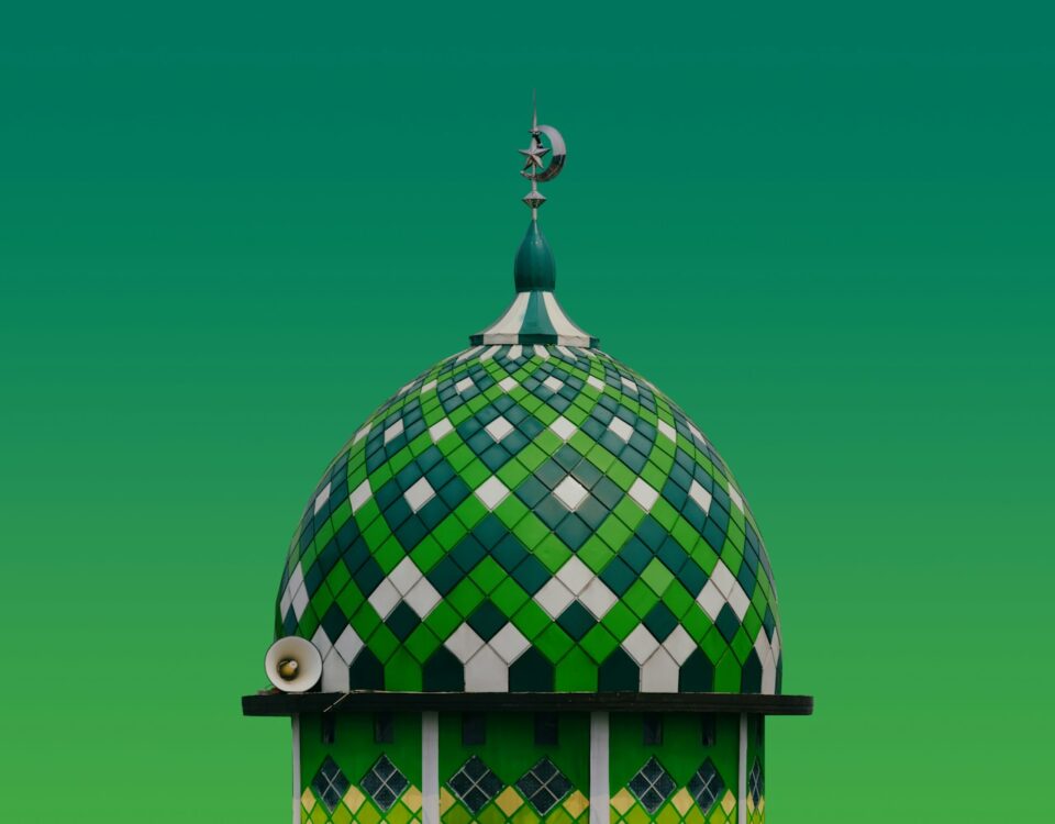 A green and white building with a clock on top