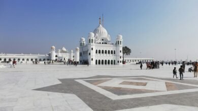 people walking on street near white concrete building under blue sky during daytime