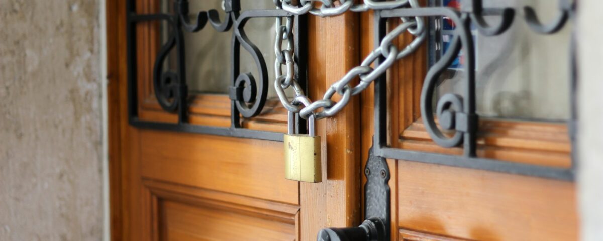 grey metal chain on brown wooden door