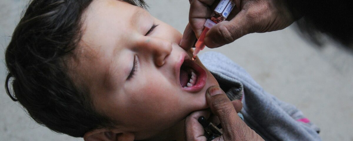 a little boy getting his teeth brushed by an adult